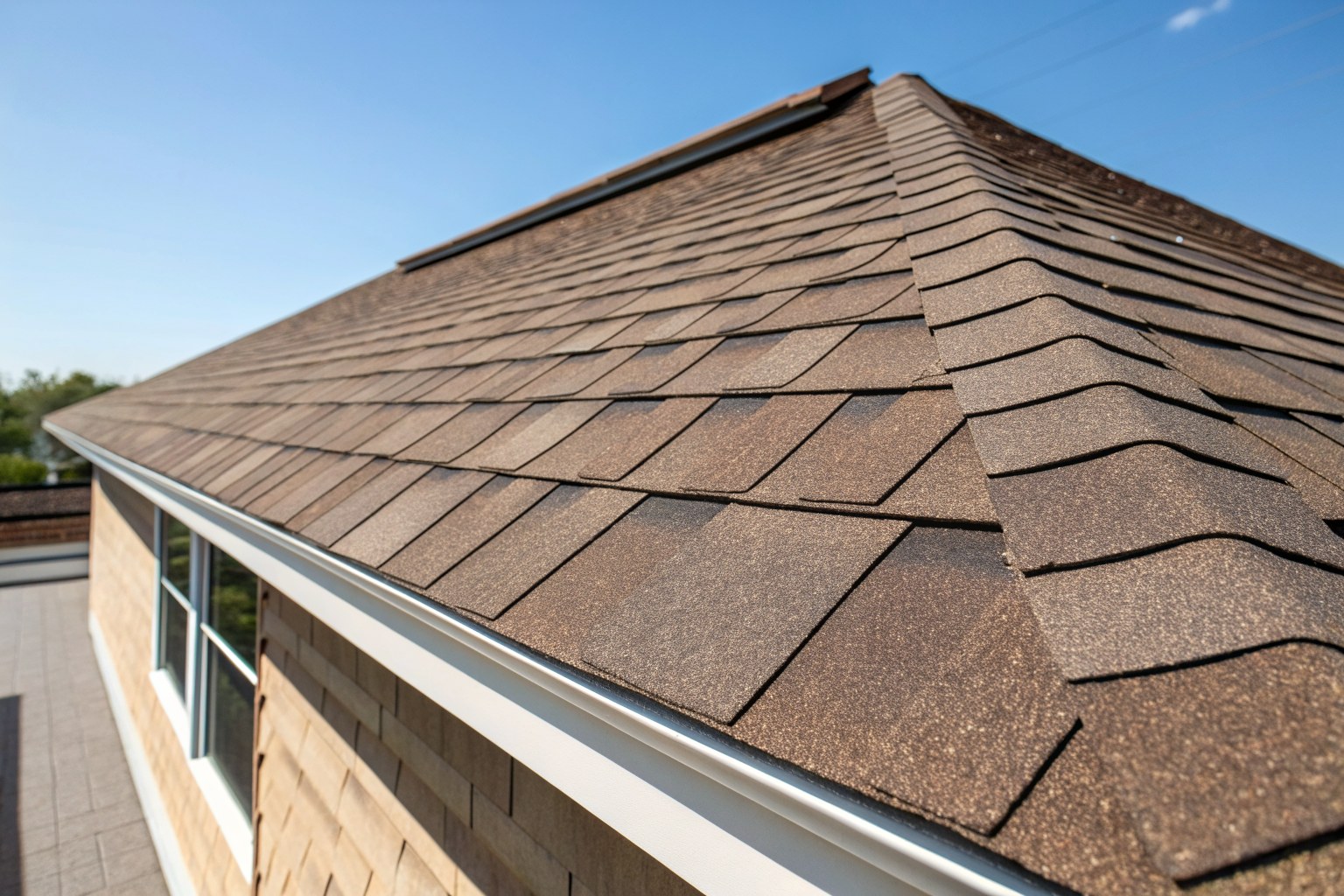 Close view of new brown architectural shingles along a straight ridge